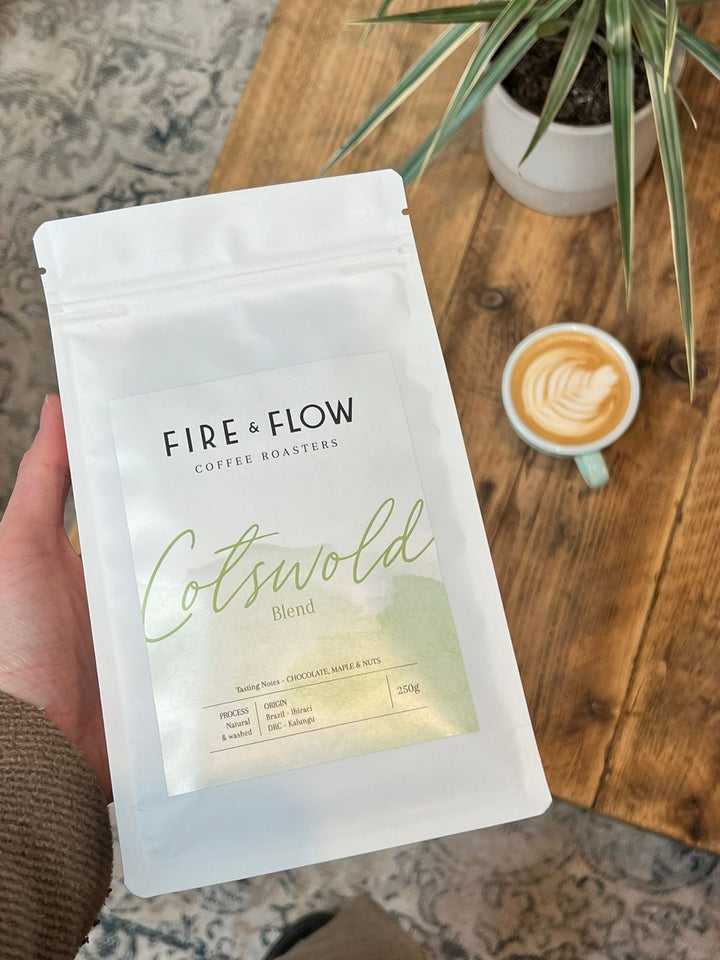 A hand holding Cotswold Blend Fire & Flow Coffee.